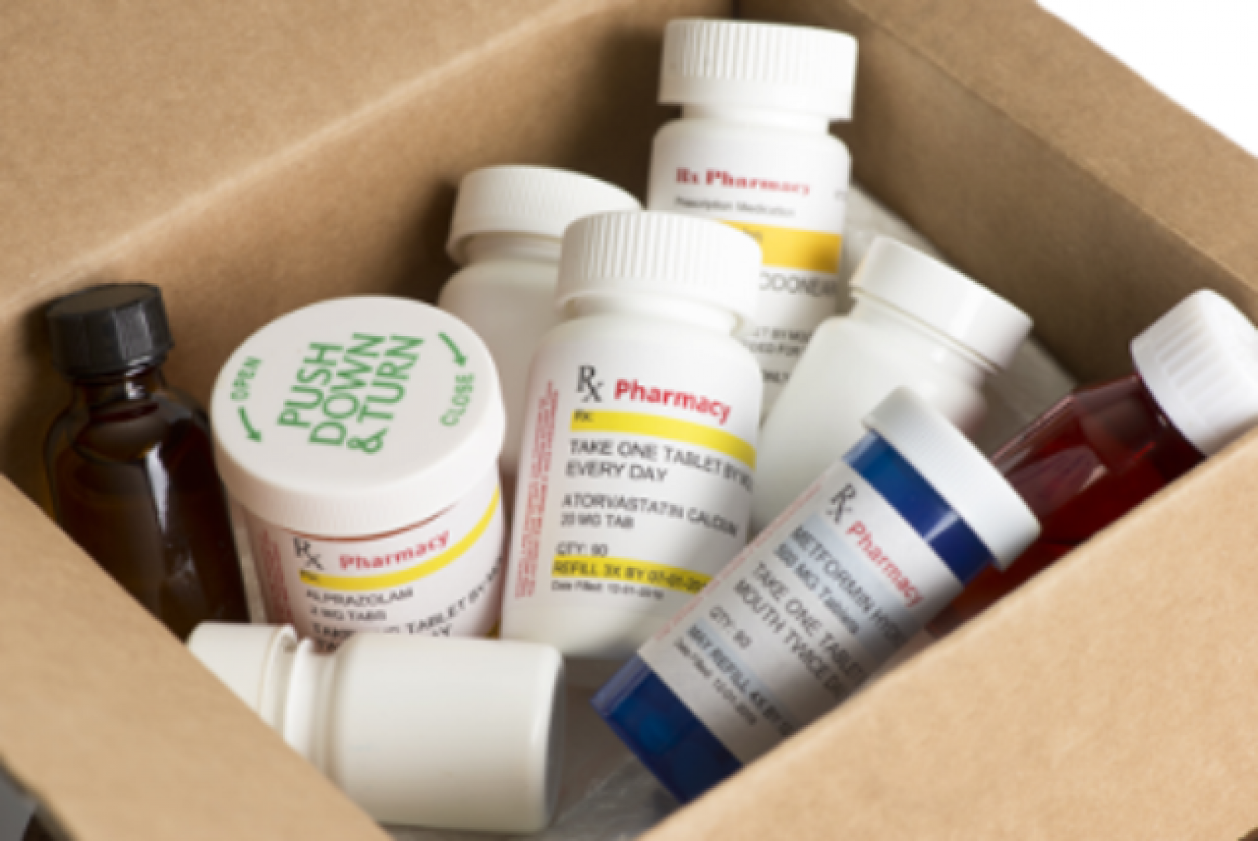 A cardboard box full of prescription drug bottles.